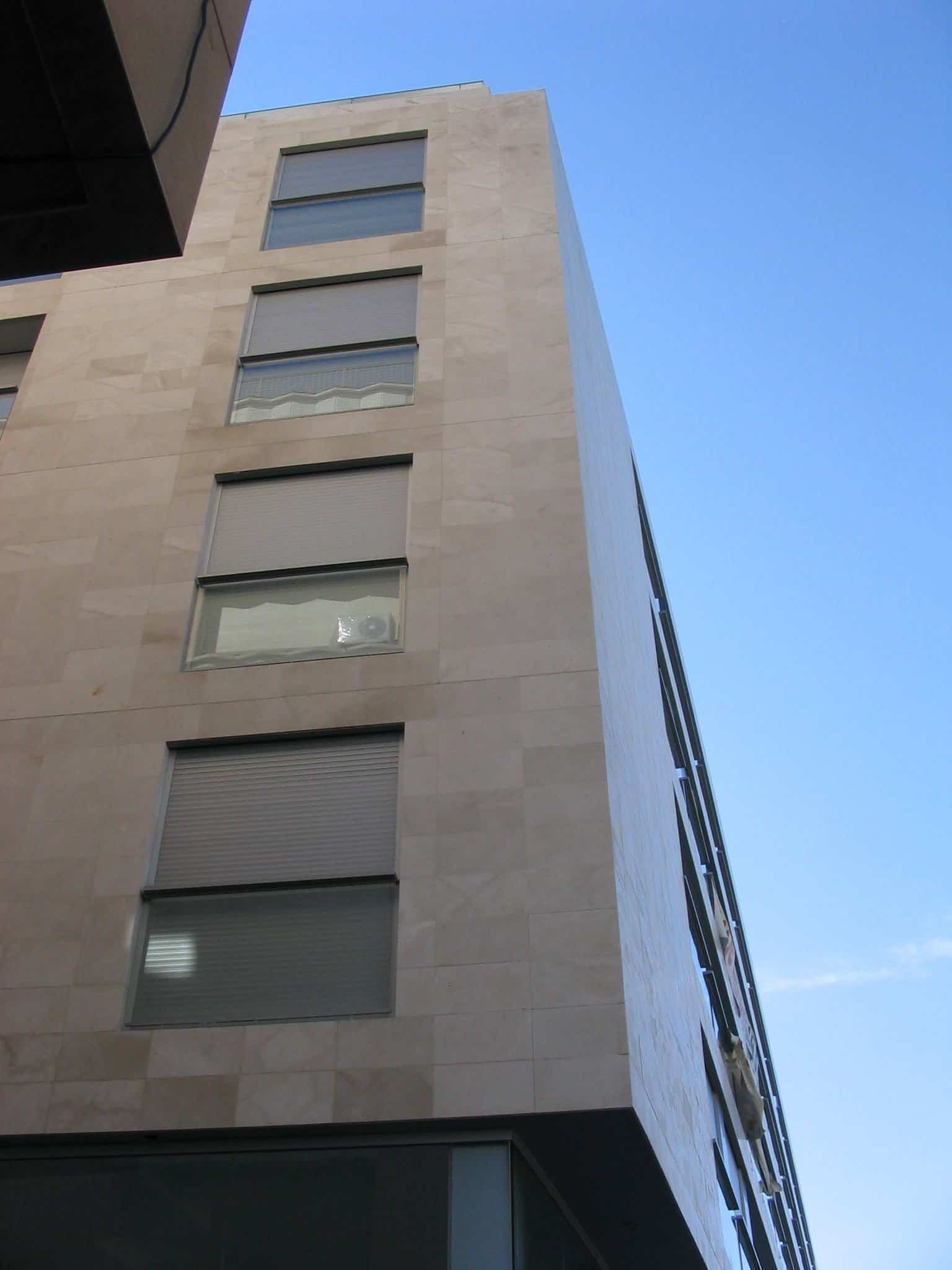 Façana de pedra clara de l'edifici 2008 Ctra Barcelona amb finestres i persianes.