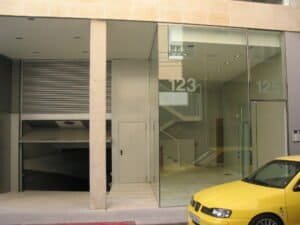 Façana edifici modern amb accés garatge i entrada de vidre