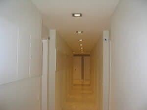 Passadís interior modern amb llums encastats i terra de marbre