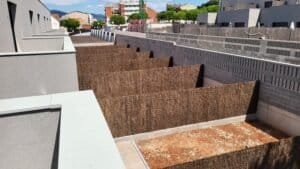 Façanes posteriors de filera de 8 cases Palau-Solità, fase 2. Jardins amb tanques de bruc.