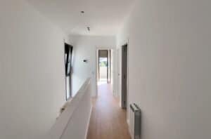 Interior modern de casa a Palau-Solità, passadís amb escala i acabats actuals.