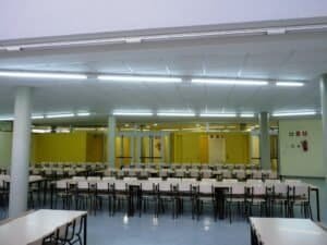 Refectori lluminós de Carmelites escollides, amb files de taules i cadires.