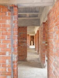 Interior en construcció de Casa Ullastrell amb murs de maó i forjat de formigó.