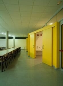 Menjador escolar amb zona de rentamans de disseny modern i mobiliari funcional.