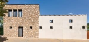 Façana principal de casa unifamiliar d’obra nova amb murs de pedra natural